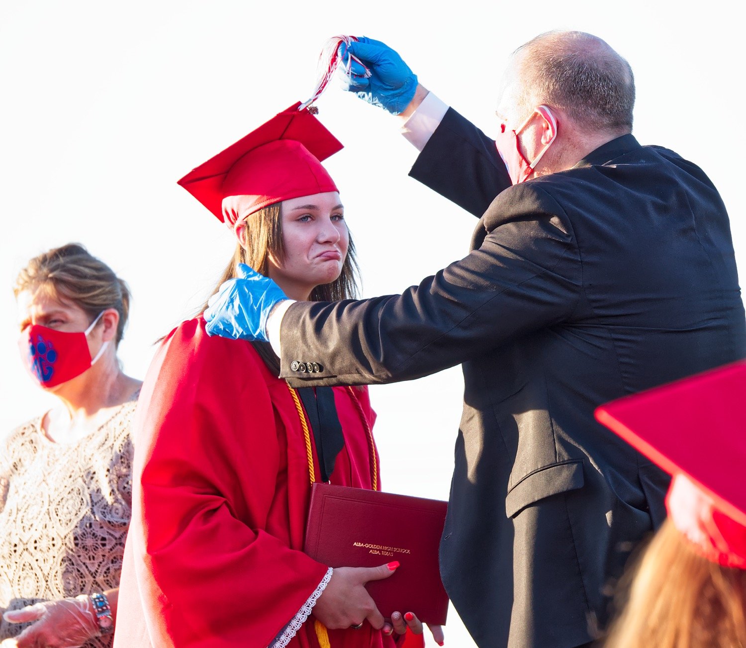 Laynie Culp seems to express mixed emotions about the occasion of her graduation as Principal Michael Mize moves her tassel of her cap.